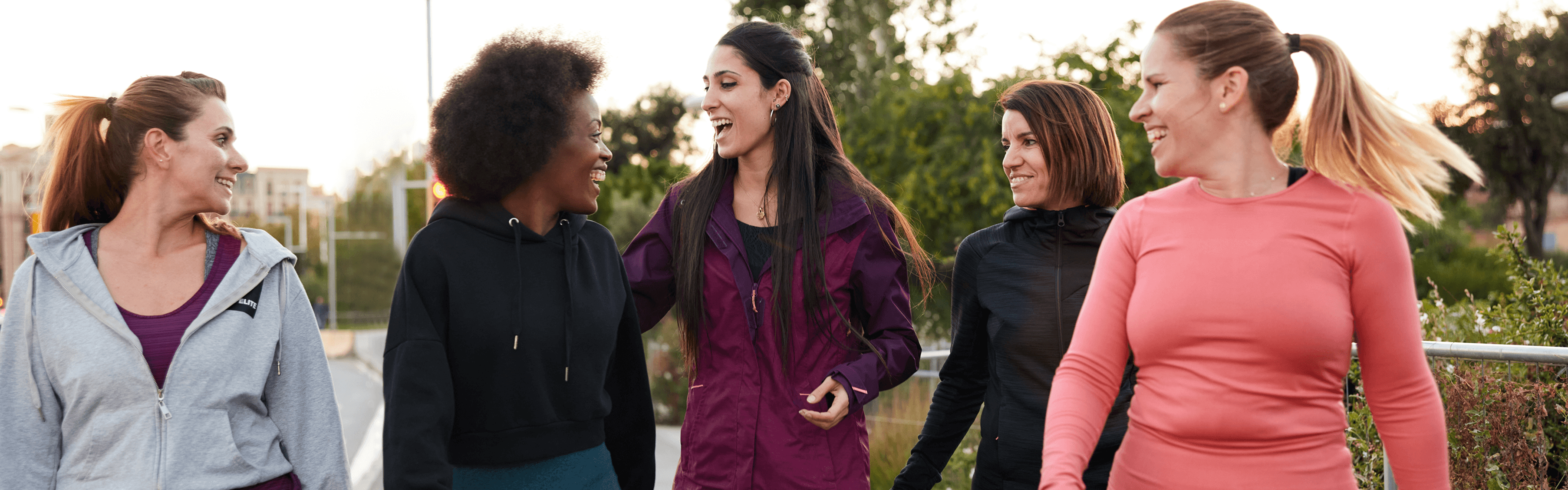 Five women walking and talking together